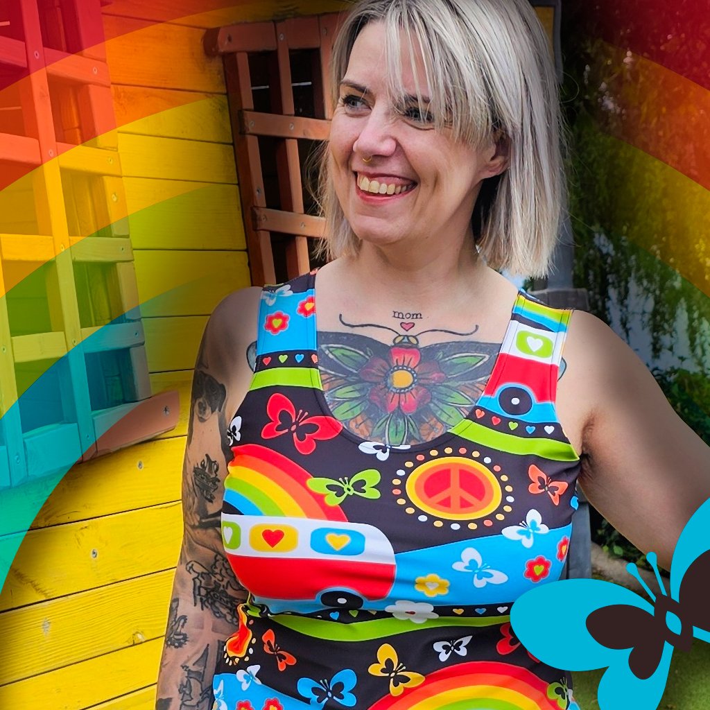 A woman smiling in a rainbow themed outfit.