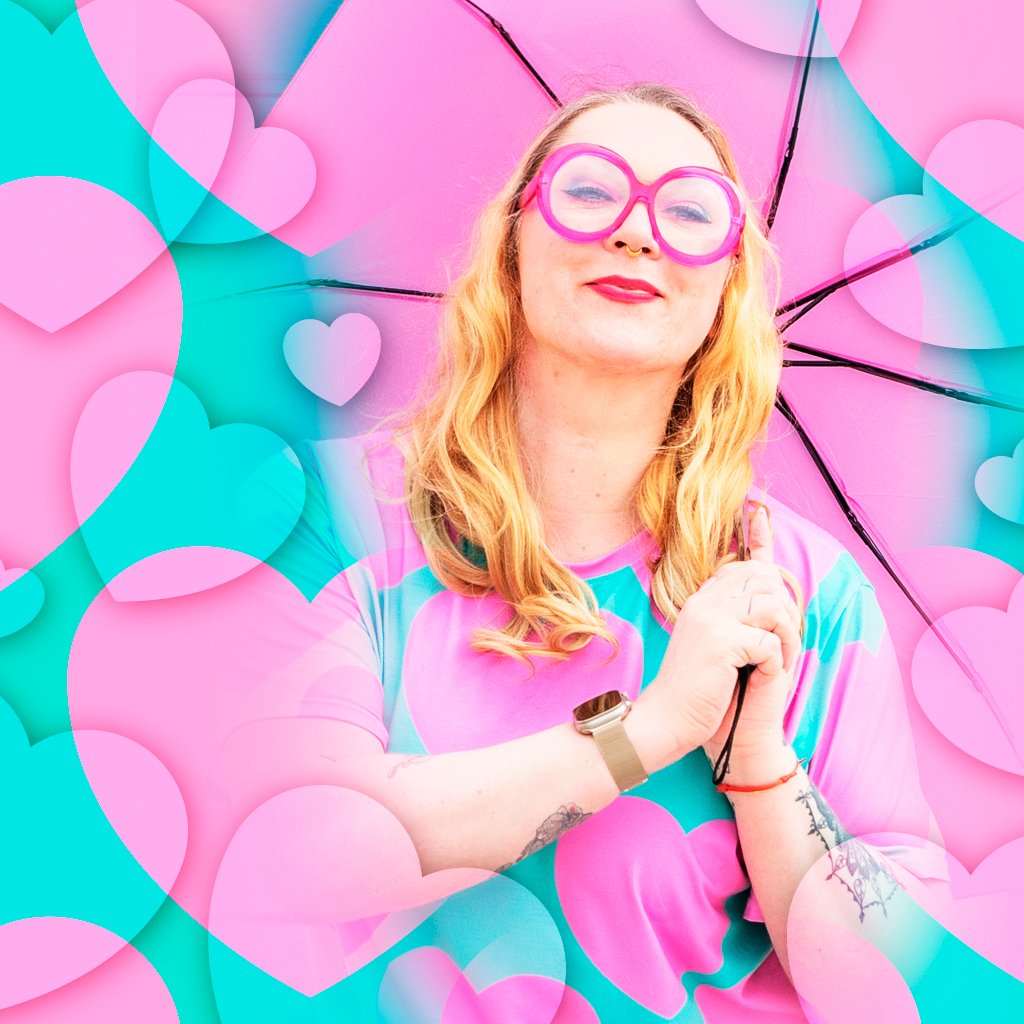 A smiling woman in pink glasses surrounded by pink hearts, wearing ELLIE LOVE pink mint t-shirt dress by SHALMIAK.