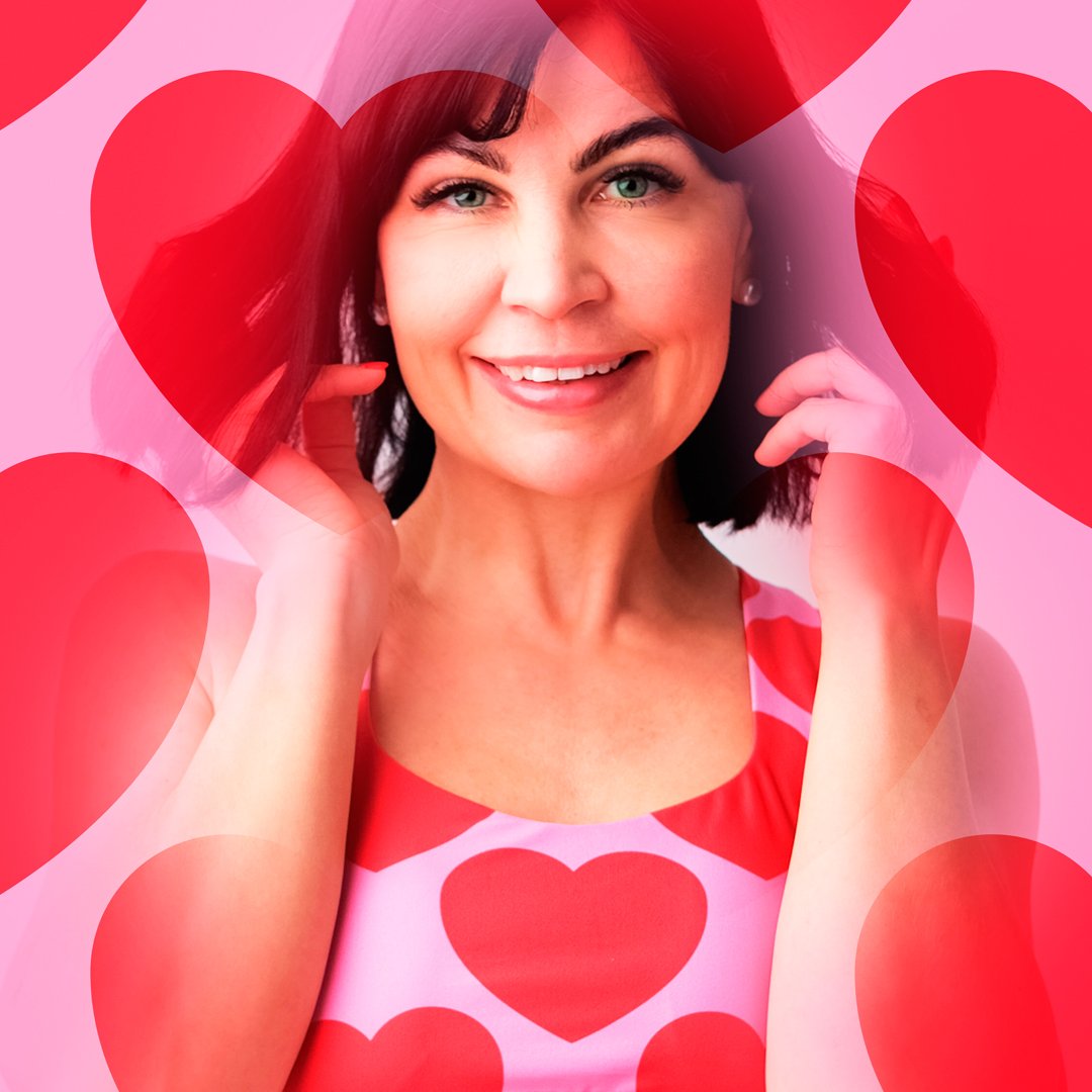 The Power of the Color Red - a smiling woman in SHALMIAK sports bras with red hearts on pink.