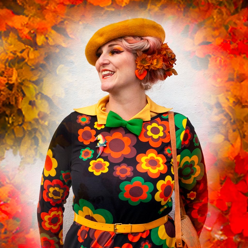 Lady in FLORA FOREVER retro midi dress by SHALMIAK featuring bold orange flowers.