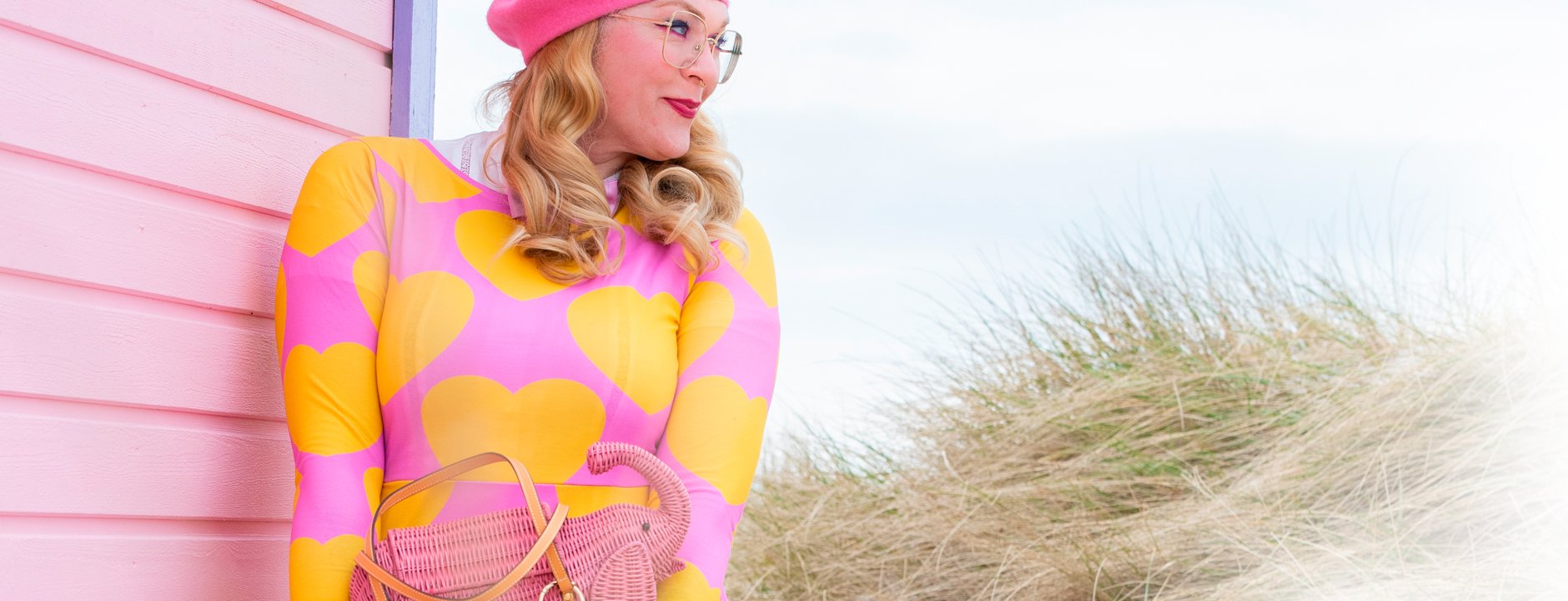 Woman wearing a colorful midi dress by SHALMIAK. Design: ELLIE LOVE yellow pink.